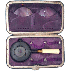 Miniature Liebreich ophthalmoscope 1875 in purple velvet fitted case with gold lettering, metal mirror, and two condensing lenses